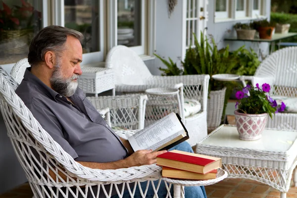 Człowiek czytanie Biblii na ganku — Zdjęcie stockowe