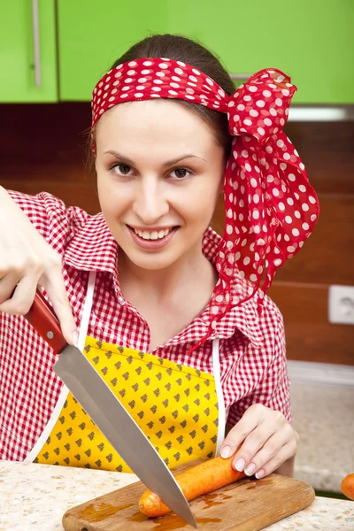 Femme dans la cuisine avec couteau et légumes — Photo