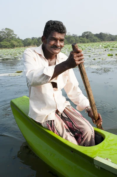 Улыбающийся азиат греет маленькую традиционную лодку — стоковое фото