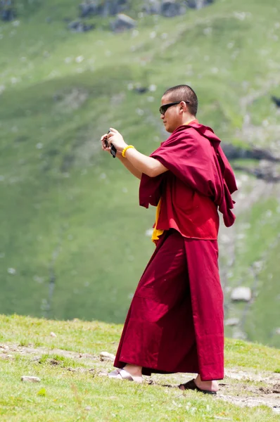 Buddhist monk takes photos in mountains — Stock Photo, Image