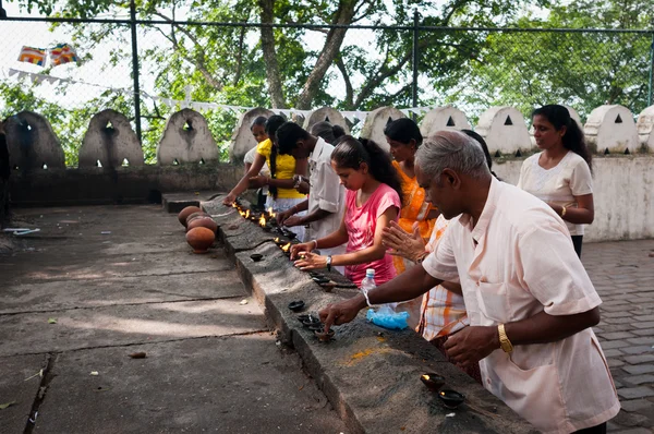 Peregrinos encienden lámparas de aceite de coco — Foto de Stock