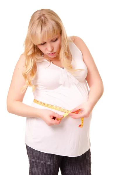 妊娠中の女性は彼女の腹を測定 — ストック写真