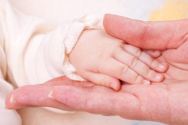 Annenin parmağını tutarken bebeğin elini yakın plan çek.