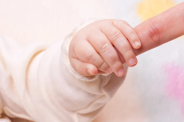Gros plan de la main du bébé tenant le doigt de la mère — Photo