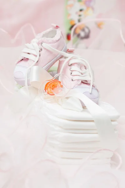 Baby shoes and orange pacifier on cotton diapers — 스톡 사진