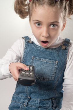 Astonished girl holding tv remote control clipart