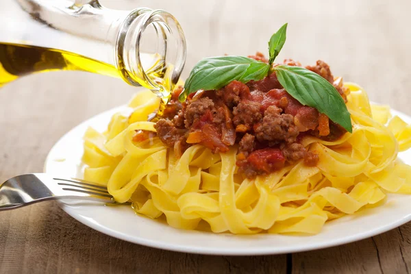 stock image Pouring oil over tagliatelle bolognese