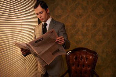 Man in suit reading newspaper clipart