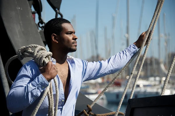 Knappe Afro-Amerikaanse zeeman tegen boten. — Stockfoto