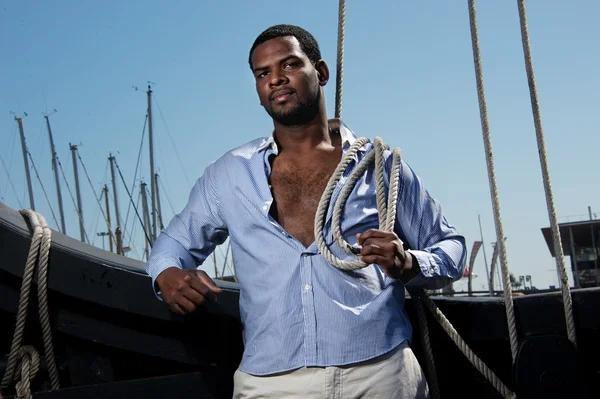 Handsome afro-american sailor against boats. — Stock Photo, Image