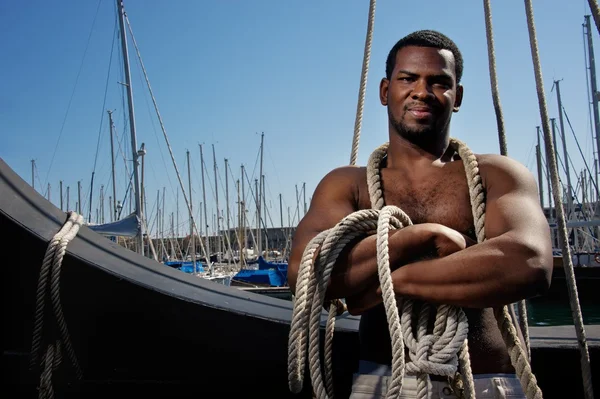 Marinheiro afro-americano bonito contra barcos . — Fotografia de Stock