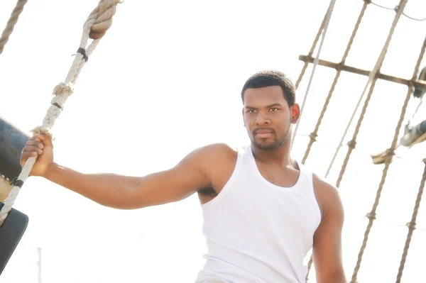 Marinheiro afro-americano bonito contra barcos . — Fotografia de Stock