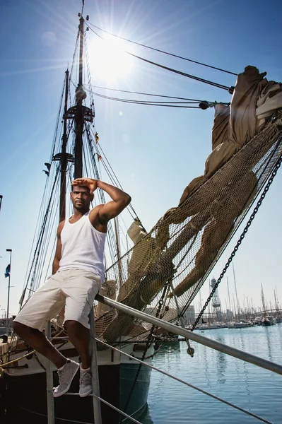 Komea afroamerikkalainen merimies veneitä vastaan . — kuvapankkivalokuva