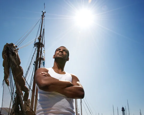 Hezký afro-american námořník proti čluny. — Stock fotografie
