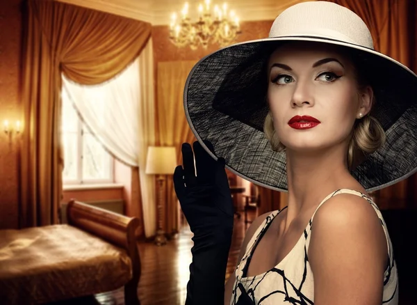 Mulher bonita em chapéu no quarto de luxo — Fotografia de Stock
