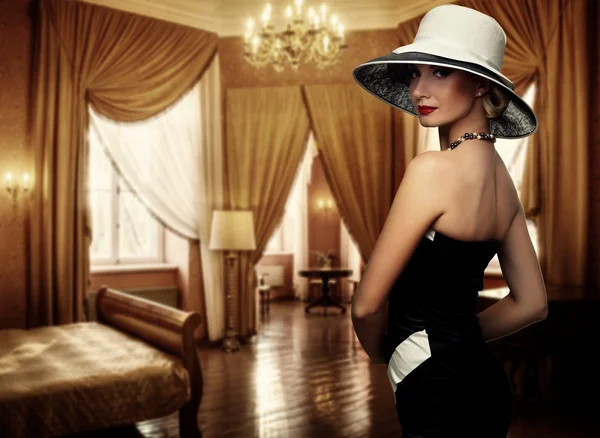 Piękna kobieta w kapeluszu w luksusowym pokoju — Zdjęcie stockowe
