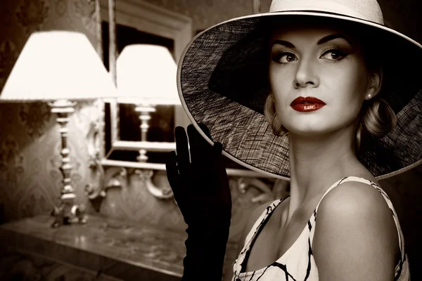 Красивая женщина в шляпе в роскошной комнате — стоковое фото