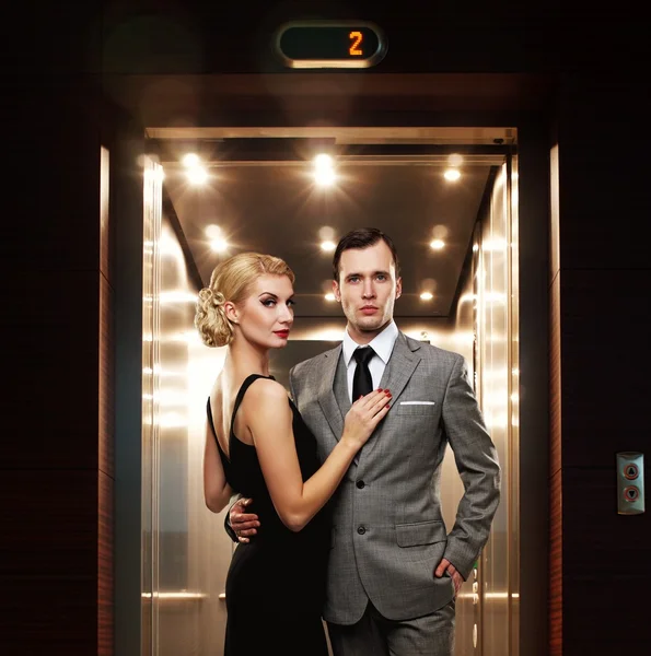 Retro paar staande tegen Lift. — Stockfoto