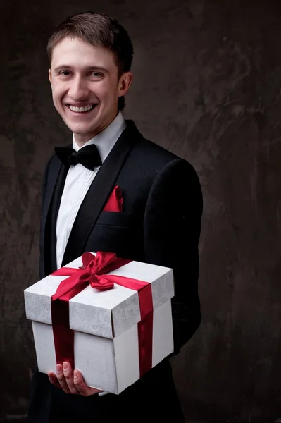 Junger Mann mit einer Geschenkbox — Stockfoto