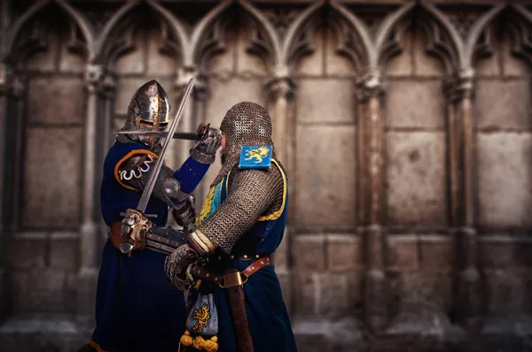 Dva rytíři boj vzdorovat stěna středověké katedrály — Stock fotografie