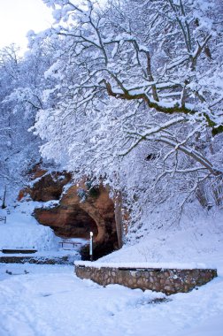 Cave in beautiful winter landscape clipart