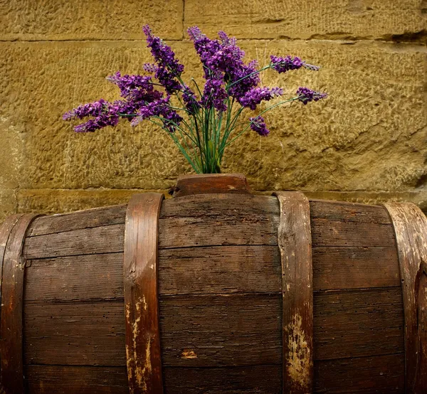 Purple flowers on old barrel. — Stock Photo, Image