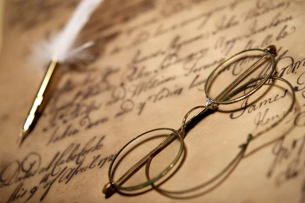 Очки и чернильница на старом письме — стоковое фото