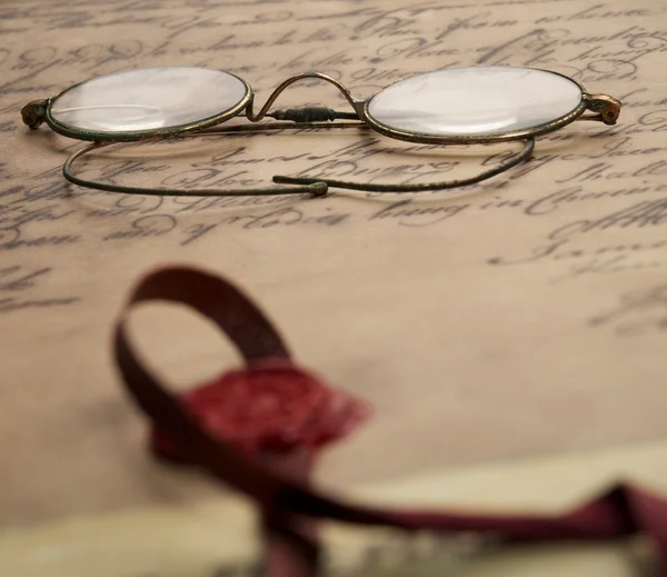 Старые очки на винтажном документе — стоковое фото