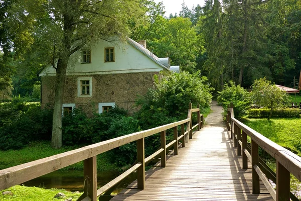 Holzbrücke und ein altes Steinhaus. — Stockfoto