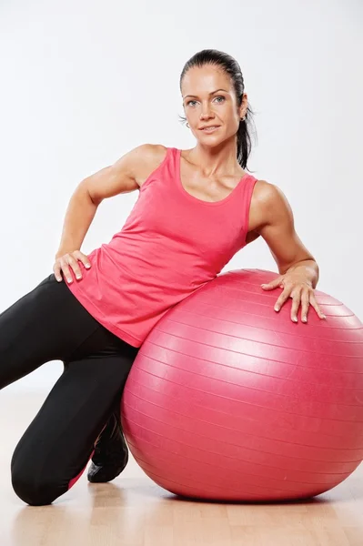 Mulher atleta bonita com uma bola de fitness — Fotografia de Stock