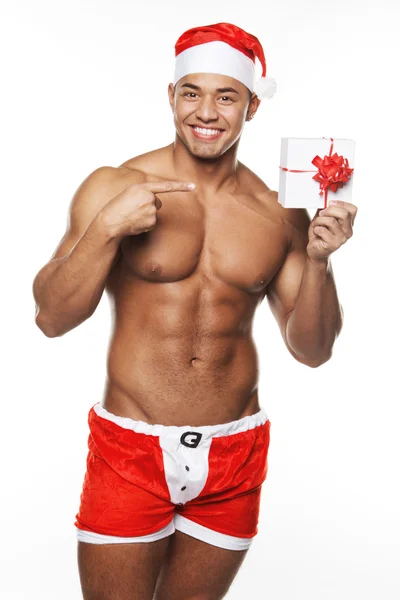 Изображение сексуального мужчины в костюме Рождества и с подарком в руках — стоковое фото