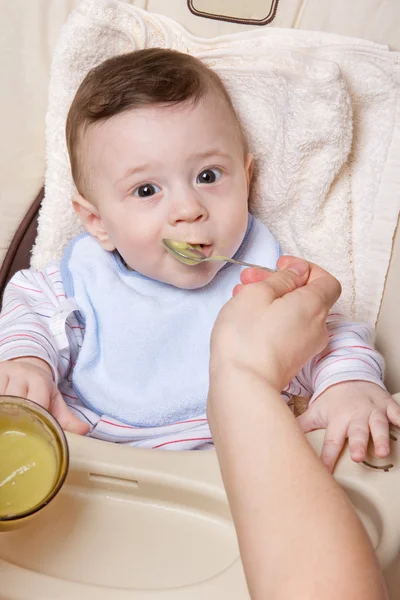 Lille baby spiser fra skje – stockfoto