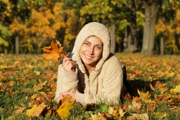 Приваблива молода жінка проти осіннього листя — стокове фото