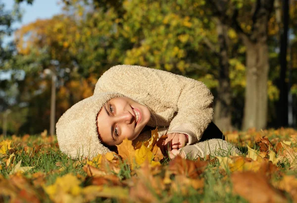 Приваблива молода жінка проти осіннього листя — стокове фото