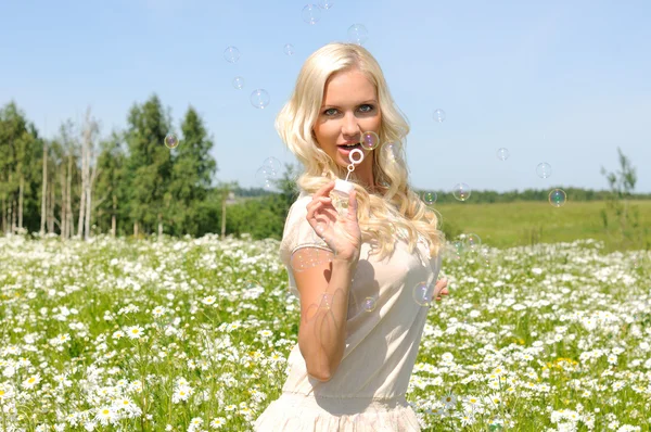 Vacker kvinna på ängen med bubblor — Stockfoto