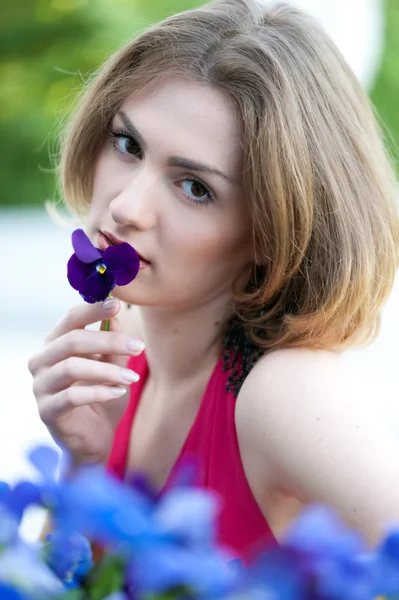 Mulher bonita que cheira a flor — Fotografia de Stock