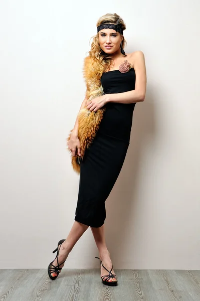Mooie vrouw in een zwarte jurk. studio portret. — Stockfoto