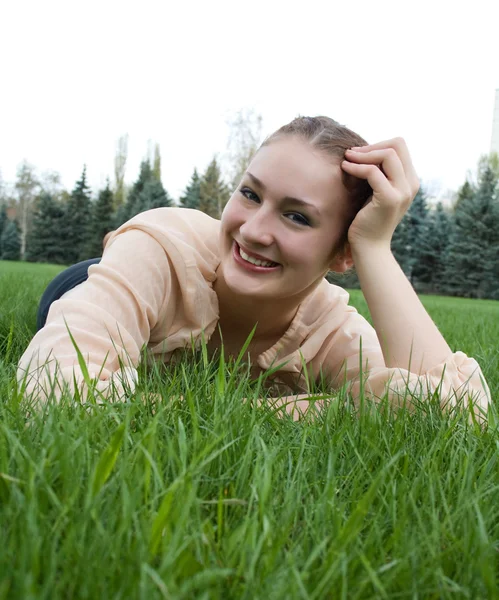 Mulher bonita que põe na grama — Fotografia de Stock
