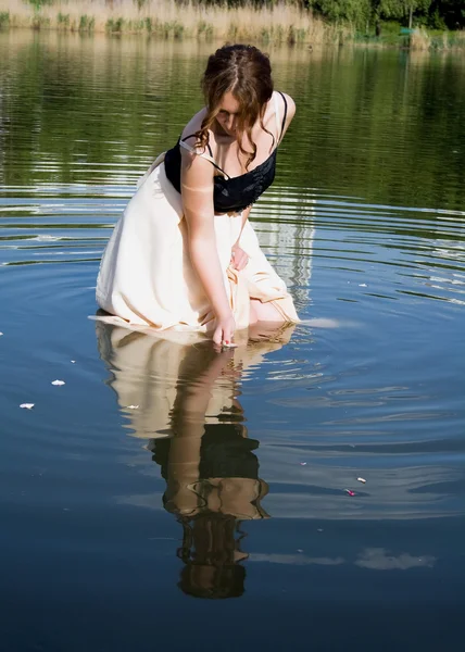 Lány nézi a tükörképét a vízben — Stock Fotó