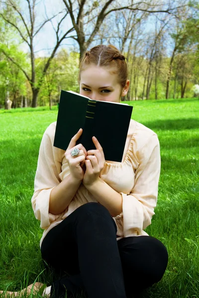 Meisje in het park met een boek — Stockfoto