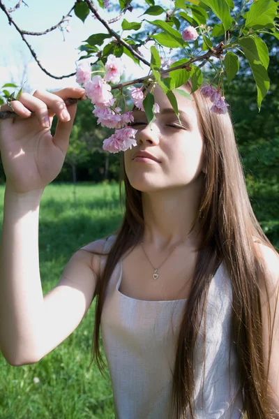 Женщина наслаждается весенним полноцветным деревом — стоковое фото