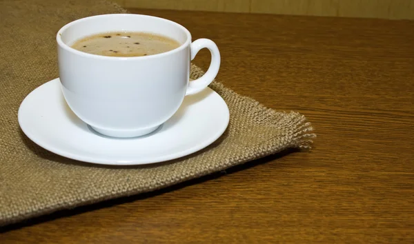 Hot cup of coffee on sack — Stock Photo, Image