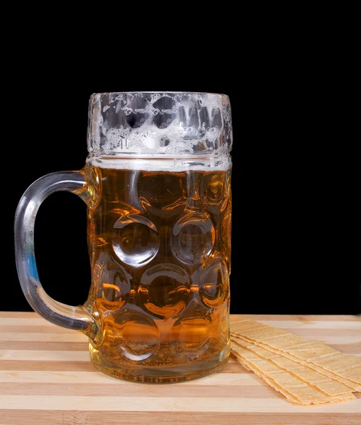 Стакан свежего пива с пеной и чипсами — стоковое фото