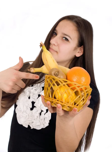 Beautiful girl holds out a basket of citrus fruit — Stock Photo, Image