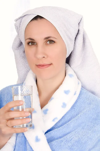 Girl in a bathrobe drinking water — Stock Photo, Image