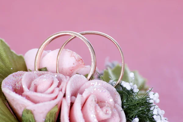 Два золотых обручальных кольца на цветах — стоковое фото
