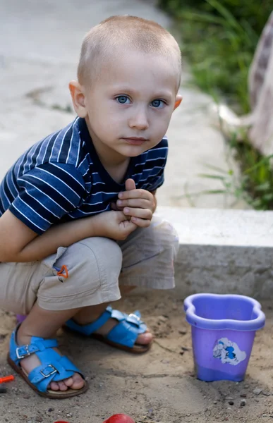 Хлопчик грає в пісочниці з іграшками — стокове фото