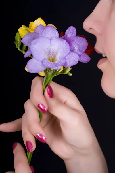 Woman sniffing flowers, freesia — Stock Photo, Image