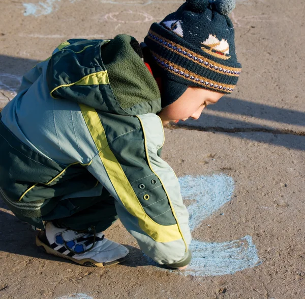 Kid playing on the ground with chalk. — Zdjęcie stockowe