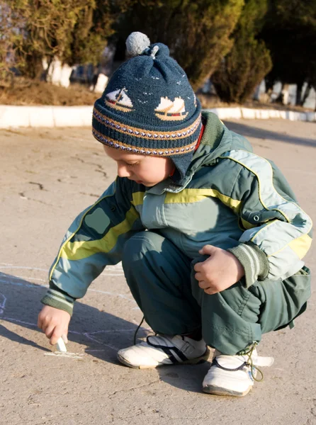 Ребенок играет на земле с мелом . — стоковое фото